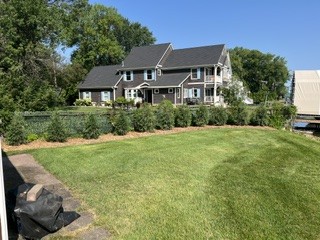 After: new arborvitae privacy hedge with mulch and sod