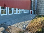 After: new paver edging and fresh landscape rock along the barn
