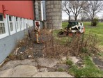 Before: old landscape rock and weeds along the barn foundation