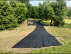 After: cleared hillside with erosion fabric installed near the pond